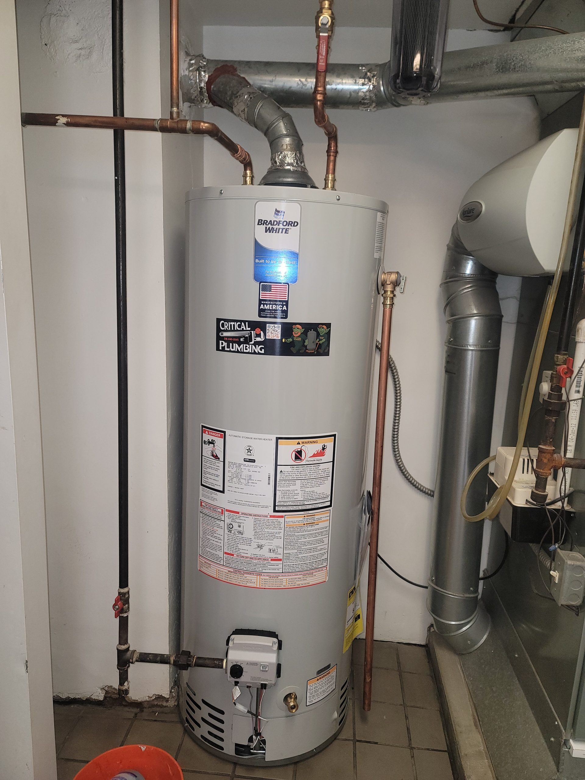 Bradford White 50-gallon gas water heater installation by Critical Plumbing in Greater Cleveland, with branded service sticker visible
